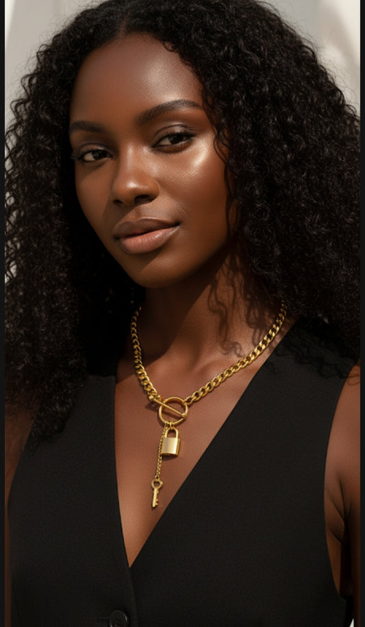 Woman wearing a gold necklace with a lock pendant