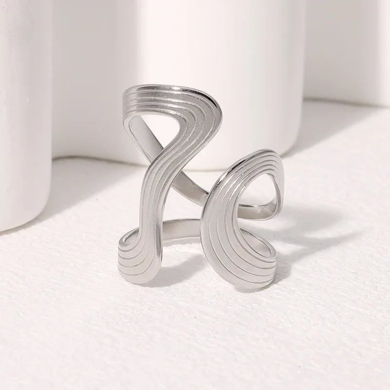 Silver ring with wavy design on a white background