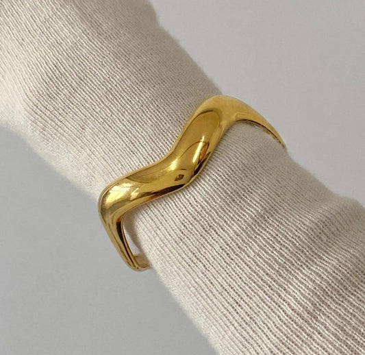 18K PVD gold-plated bold bracelet on a beige fabric background