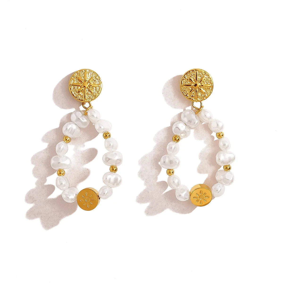 Pair of pearl earrings with white beads and gold accents on a white background