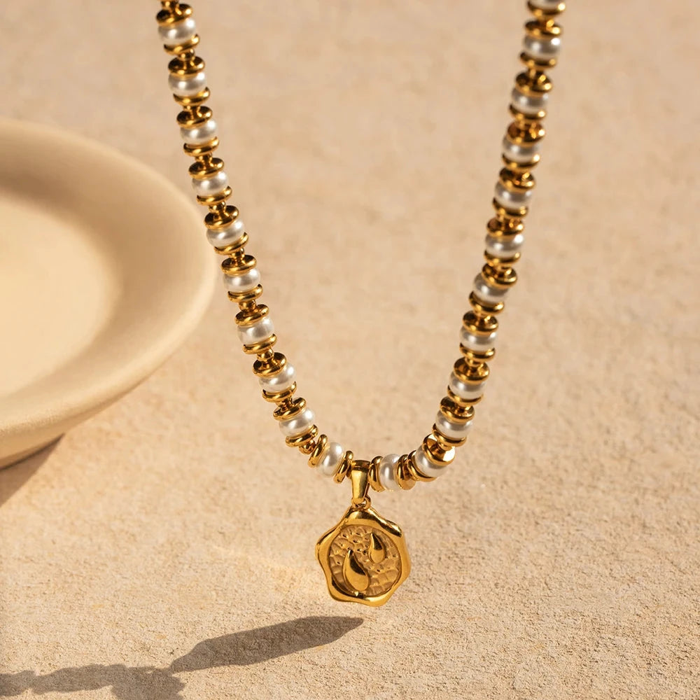 Necklace with gold and pearl beads on a beige background