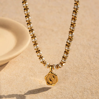 Necklace with gold and pearl beads on a beige background