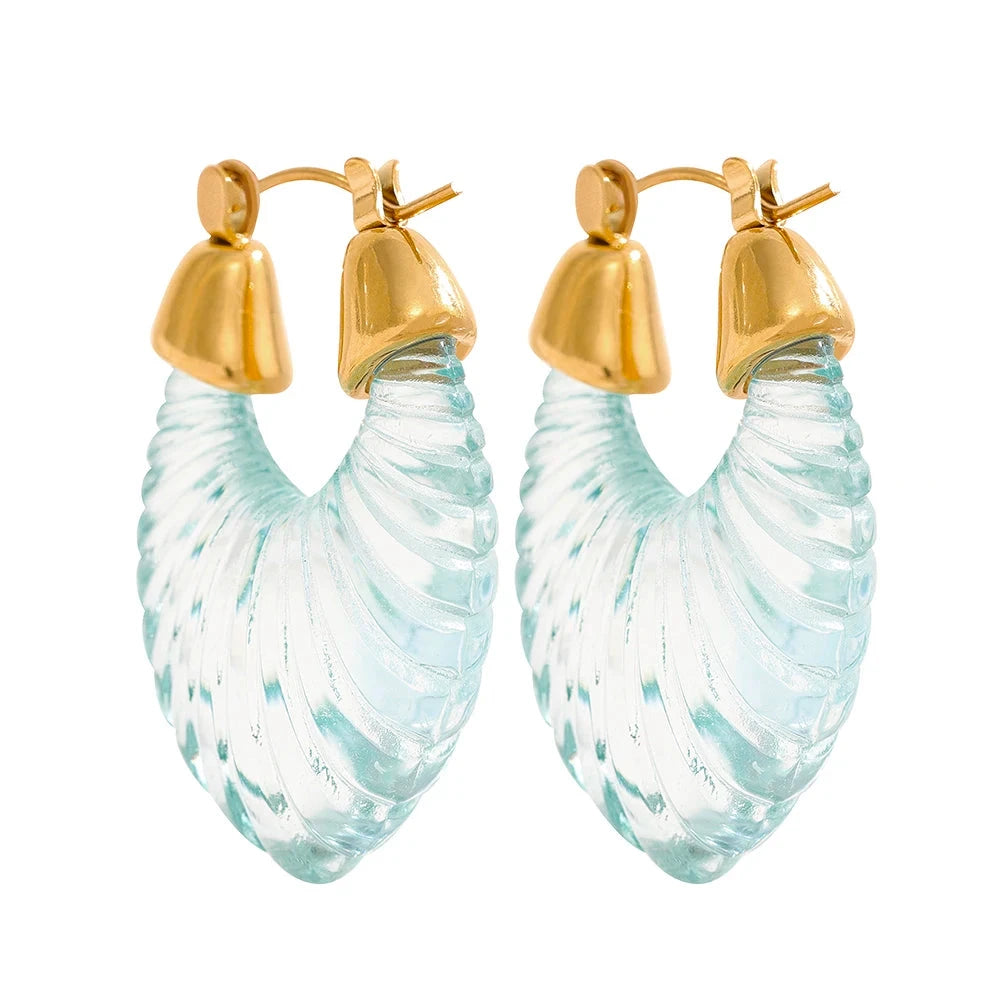 Pair of stainless steel earrings with gold tops and light blue, wavy designs on a white background