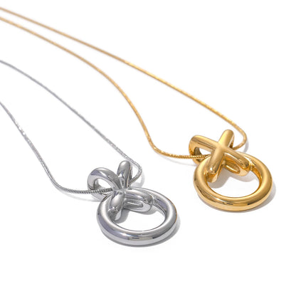 Two XO pendant necklaces, one in silver and one in gold, hanging from a snake chain link. 18k PVD gold-plated stainless steel