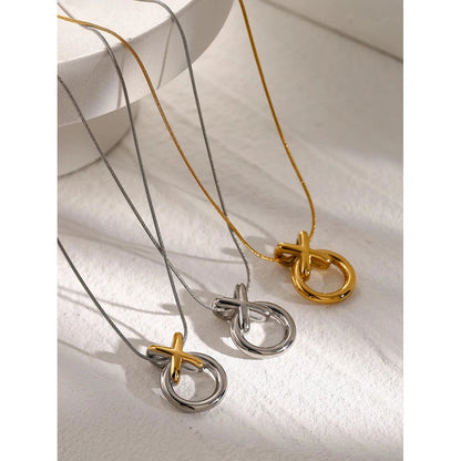 Two gold and silver necklaces with unique XO pendants on a white surface