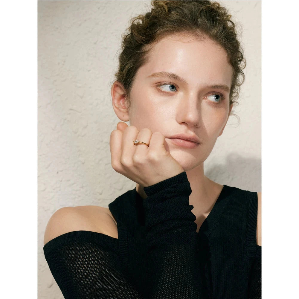 Woman wearing a black top with a textured beige background