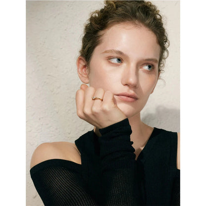 Woman wearing a black top with a textured beige background