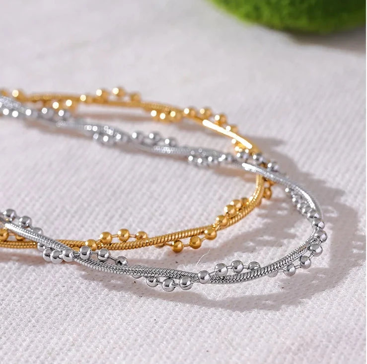  one gold-colored and one silver stainless steel twine fashion collar necklace with a geometric pattern, displayed against a white background.