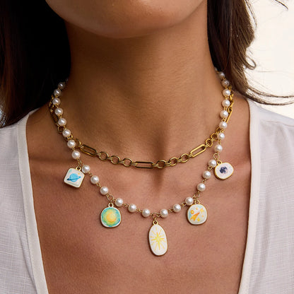 Necklace with pearl chain and colorful pendant charms worn by a person