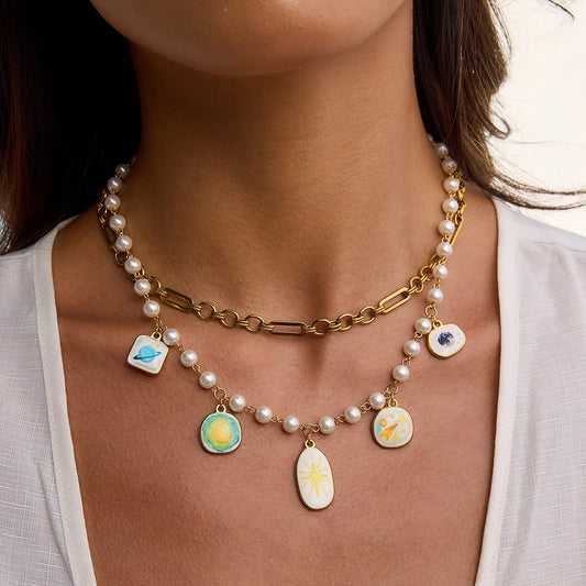 Necklace with pearl chain and colorful pendant charms worn by a person