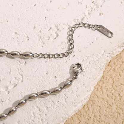 Silver chain bracelet on a textured beige surface