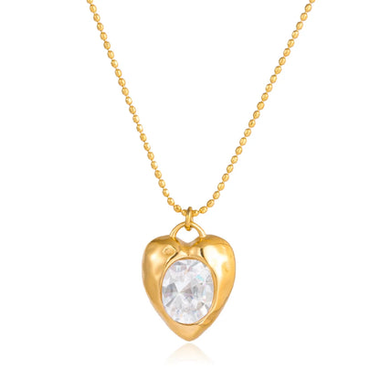Gold heart-shaped necklace with a clear gemstone on a white background