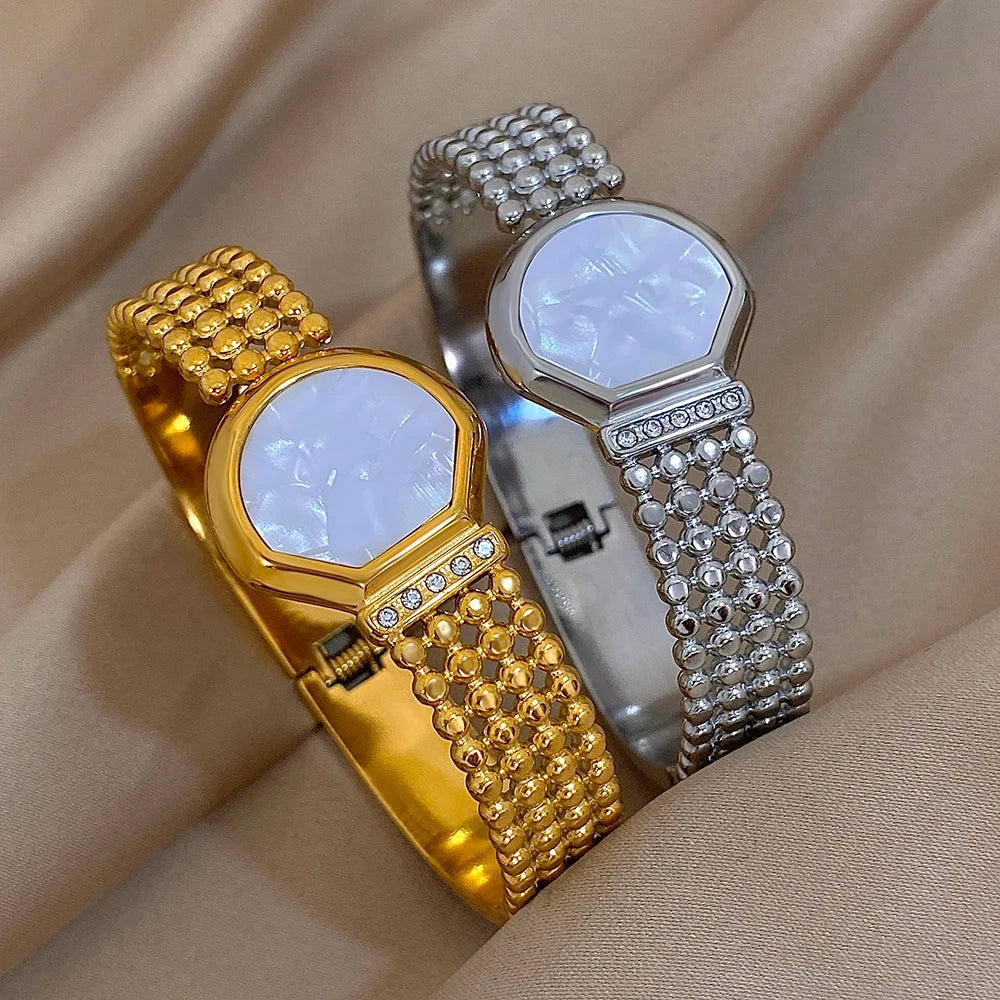 Gold and silver beaded wristbands on a beige fabric background