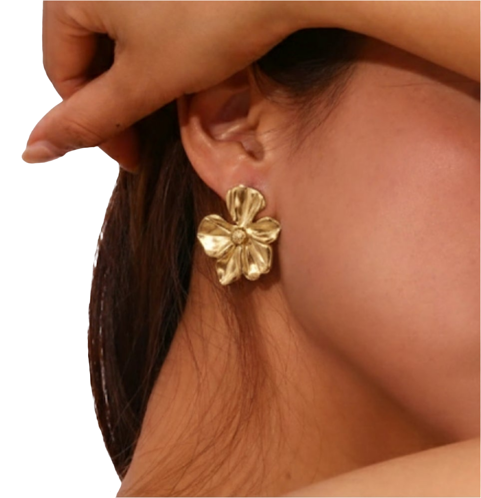 Gold flower earring worn by a model with a neutral background