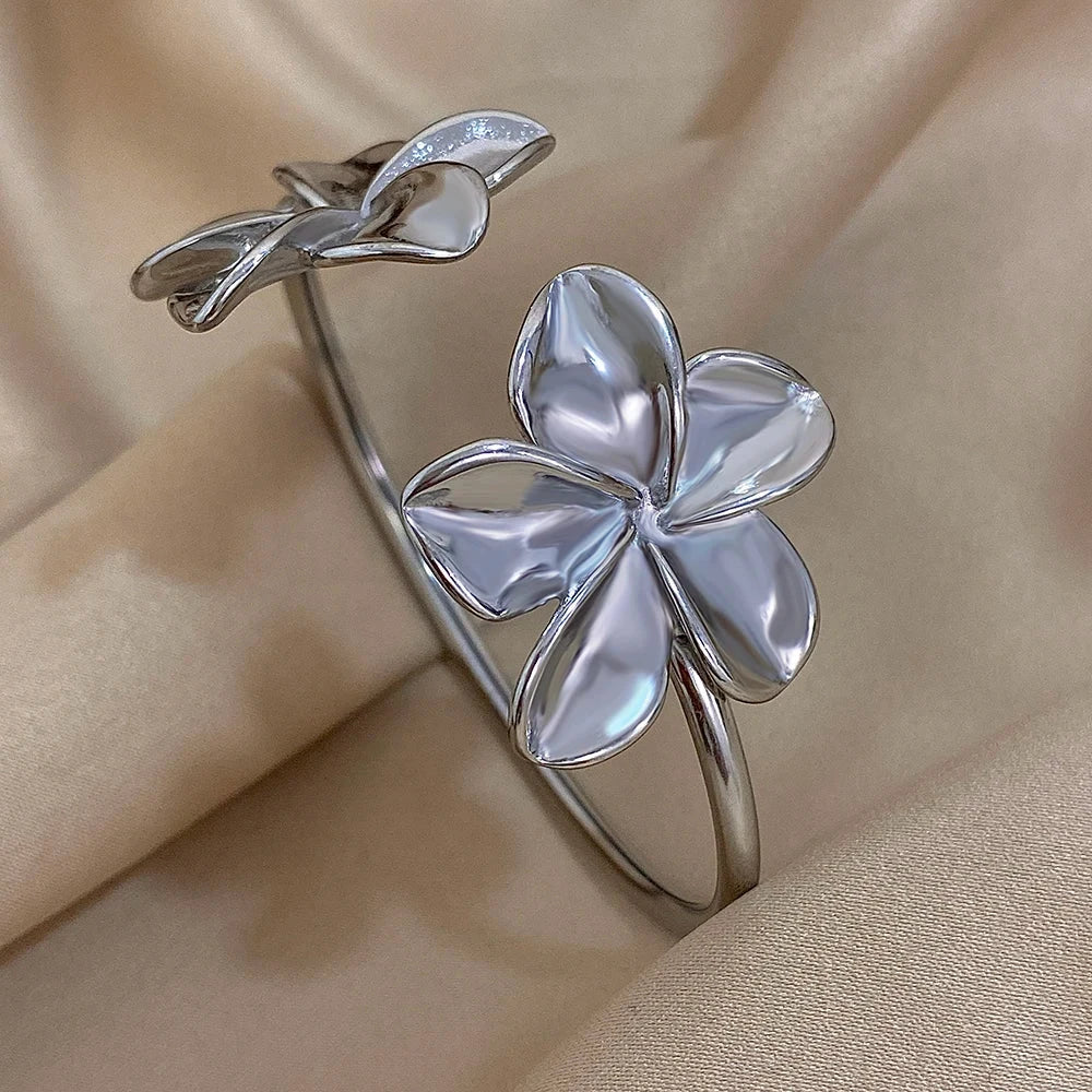 Silver flower-shaped bracelet on a beige fabric background