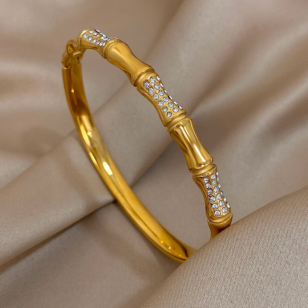 Gold bracelet with diamond accents on a beige fabric background