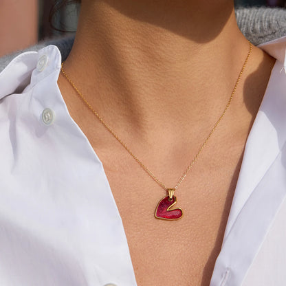 18K Gold necklace with a red heart pendant worn by a person in a white shirt.