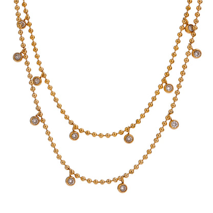 An 18K gold-plated necklace with a double layer of chain and sparkling cubic zirconia bezel stones.