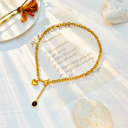 Gold necklace with a heart and black pendant charm