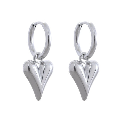 Close-up of stainless steel huggie hoop earrings with a heart design on a white background.