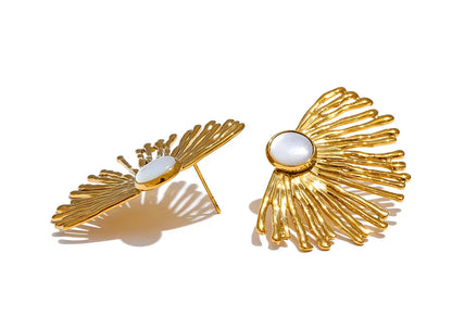 Gold earrings with a central white gemstone on a white background