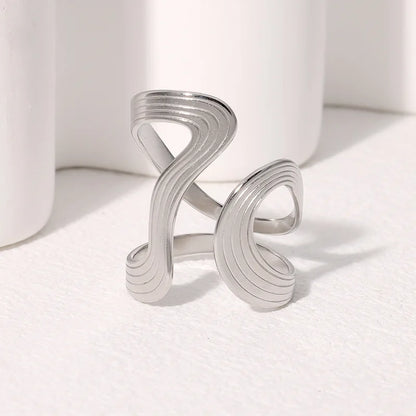 Silver ring with wavy design on a white background