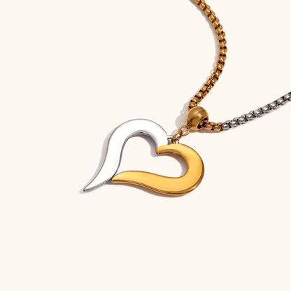 Angled view of the open heart pendant, emphasizing the two-tone look and clean edges of the mixed metal design.