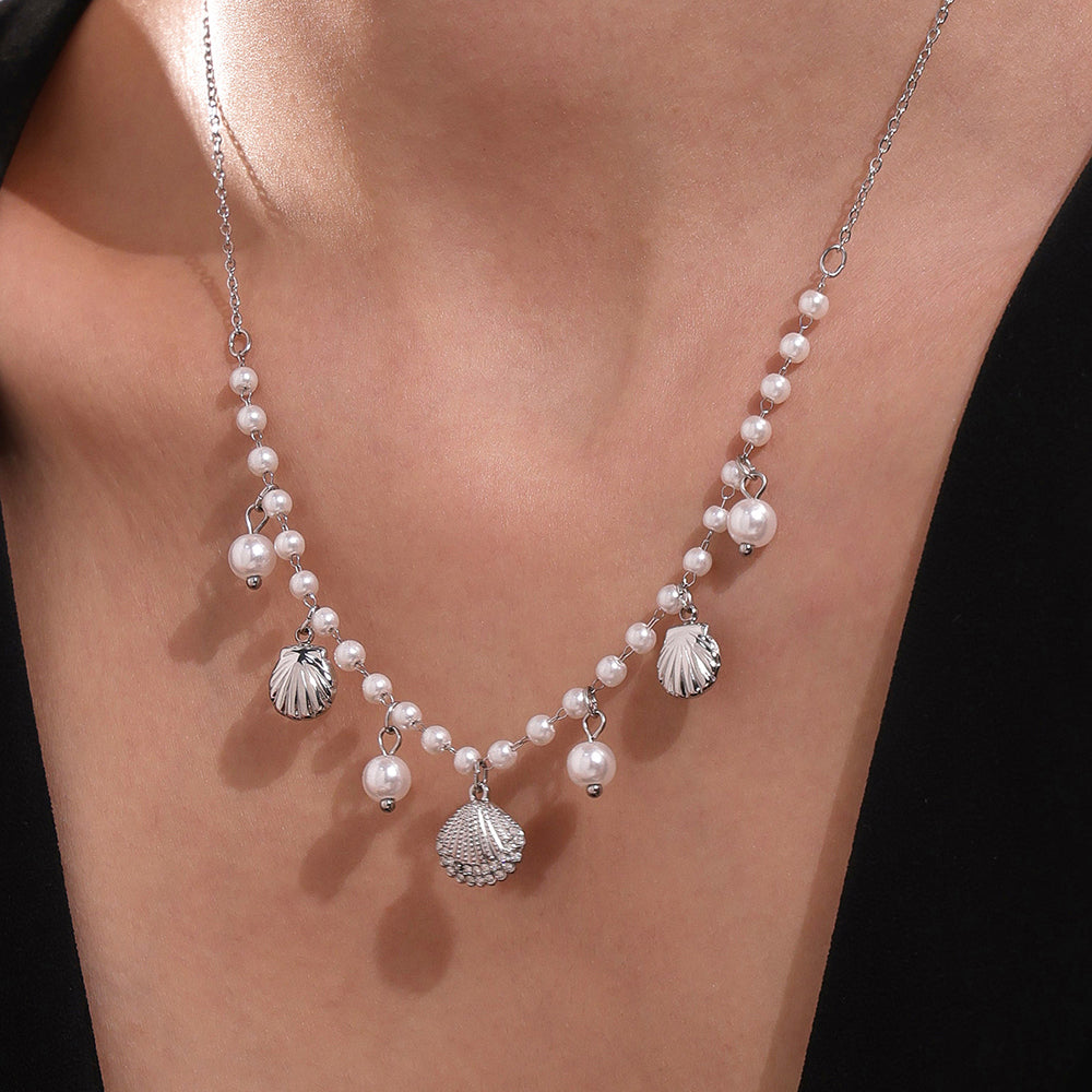Stainless steel Pearl necklace with shell charms on a model against a black background