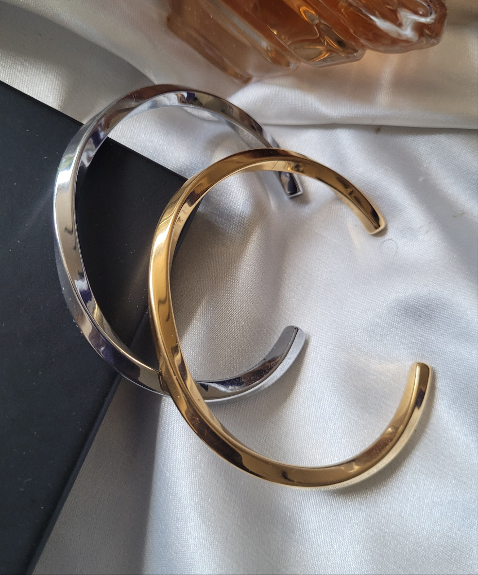 Gold and silver bangles on a light fabric background