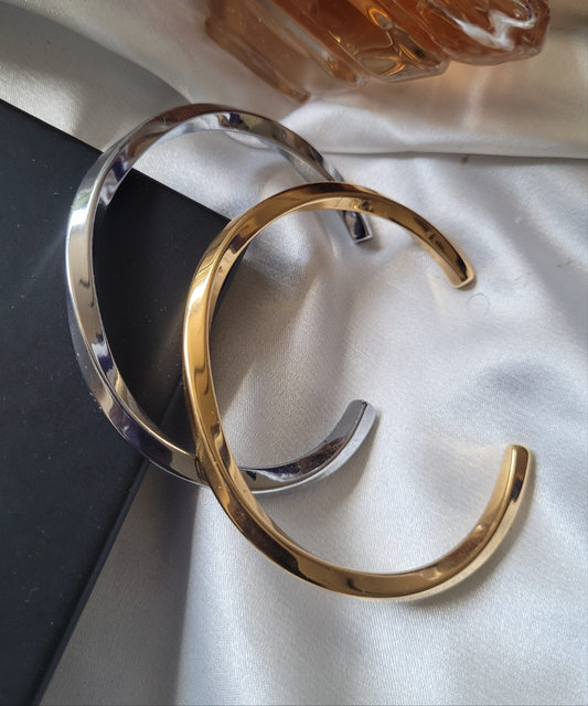 Gold and silver bangles on a light fabric background