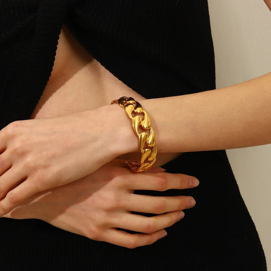 Valentina Luxe Gold Bangle worn on a model's wrist, showing its substantial width and sleek fit.
