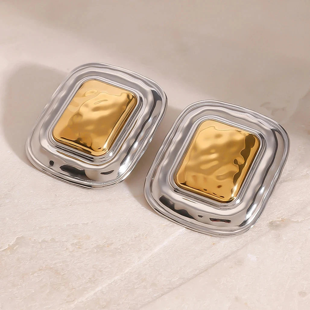 Studio shot of the polished, architectural square earrings, highlighting the contrast between the gold and silver plating.