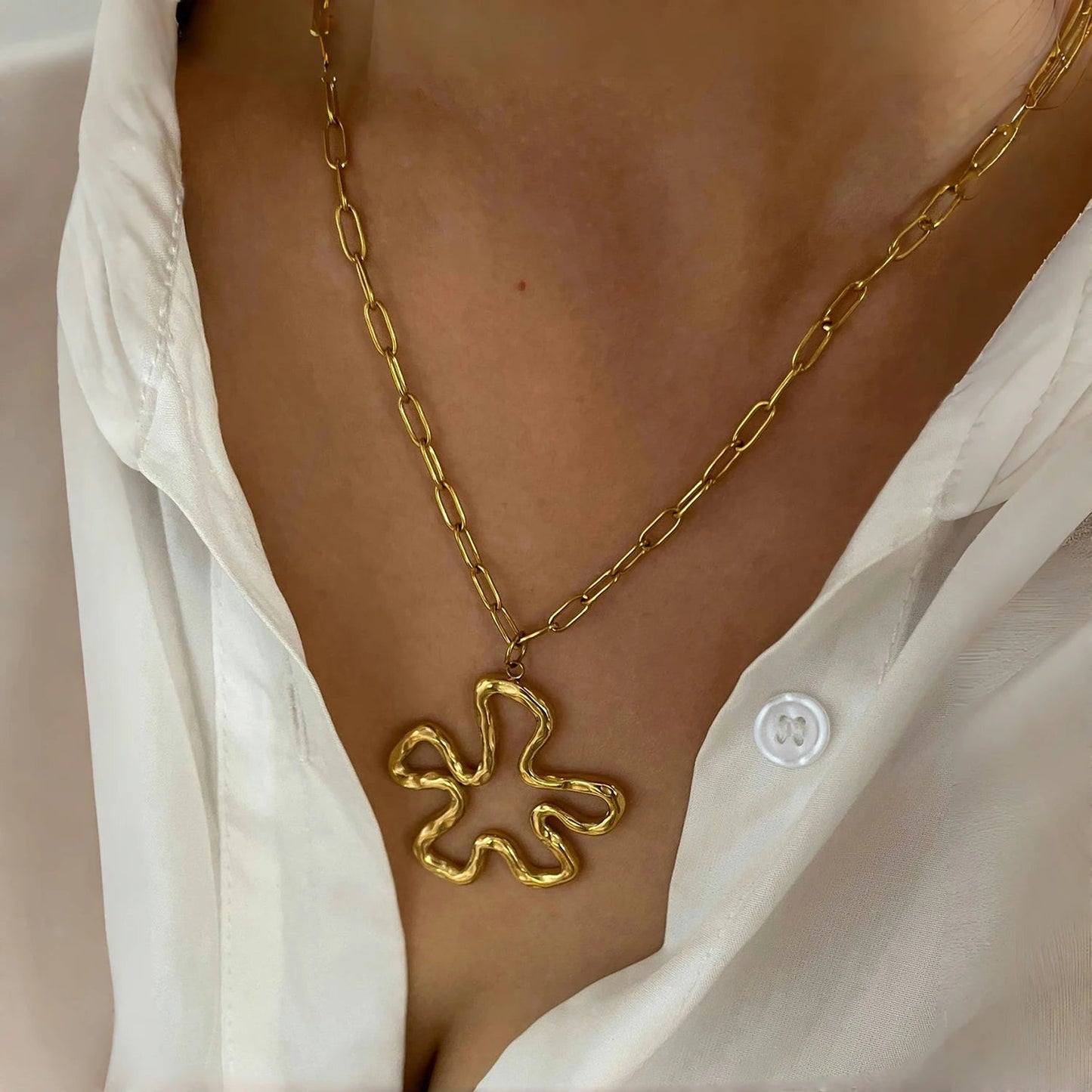 Model wearing vintage floral pendant necklace — minimalist gold chain and hollow flower charm at collarbone