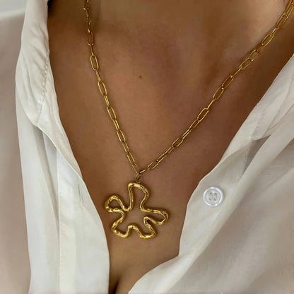 Model wearing vintage floral pendant necklace — minimalist gold chain and hollow flower charm at collarbone