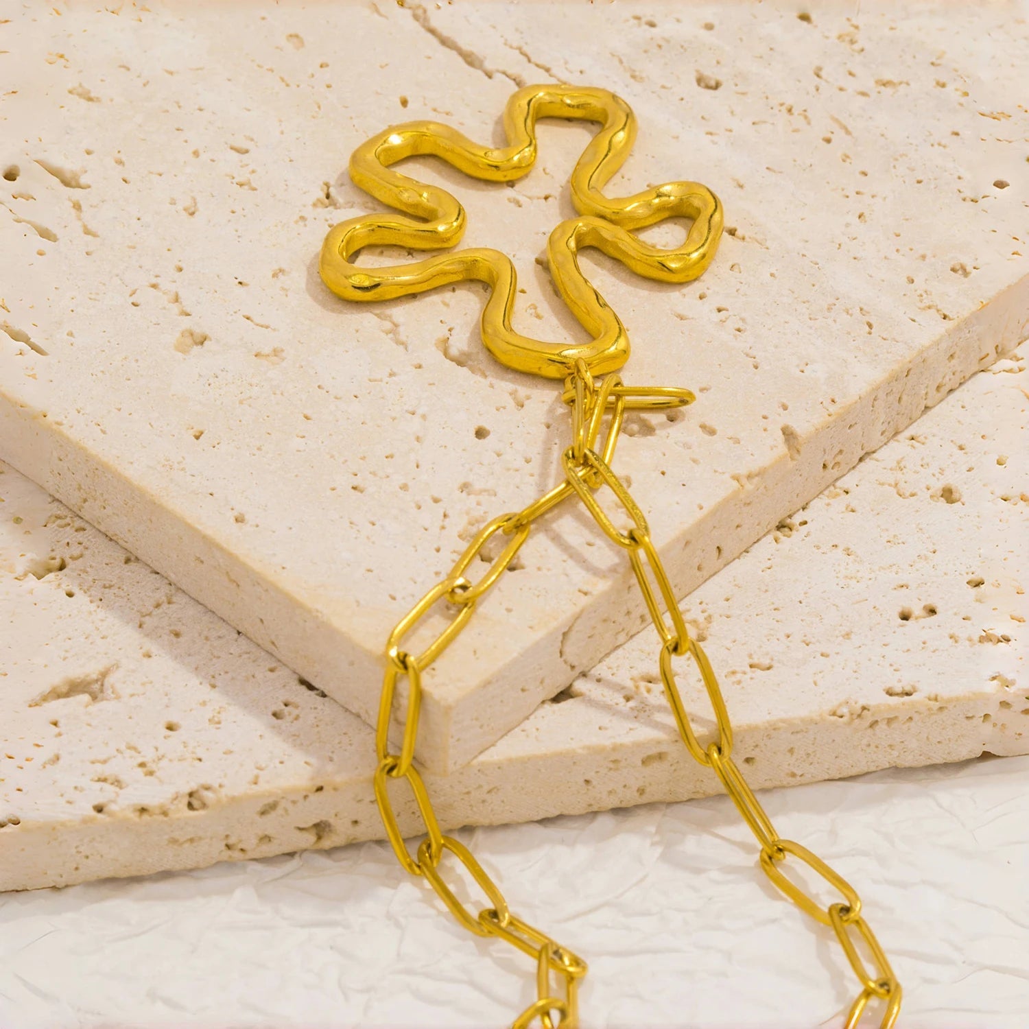 Close-up of flower pendant showing hollow petals and polished gold-plated metal finish