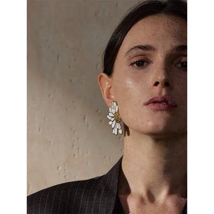 Close-up of the big sunflower drop earrings worn by a model, emphasizing their luxurious gold and white finish and 2.01-inch height.